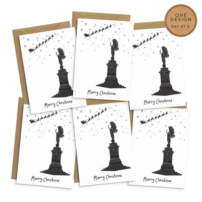 A set of 6 Christmas greetings cards on a white background. The cards all depict the same design- a hand illustrated drawing of the Brighton Peace Statue. An angel stand atop a plinth with its arm raise. Overhead smalls stars and Santas sleigh and reindeer can be seen up high.