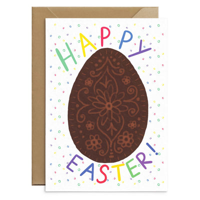 A colourful easter greetings card with an illustration of chocolate egg is surrounded by rainbow coloured polka dots and completed with bright multicoloured text that reads 'happy easter'. A white card laid on top of a recycled brown envelope. Easter Greetings Card by Poppins and co.
