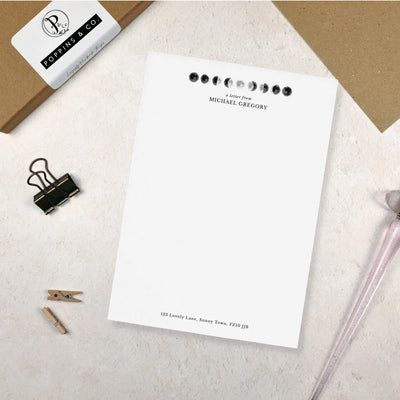 Single sheet of personalised moon themed writing paper on pale background 
