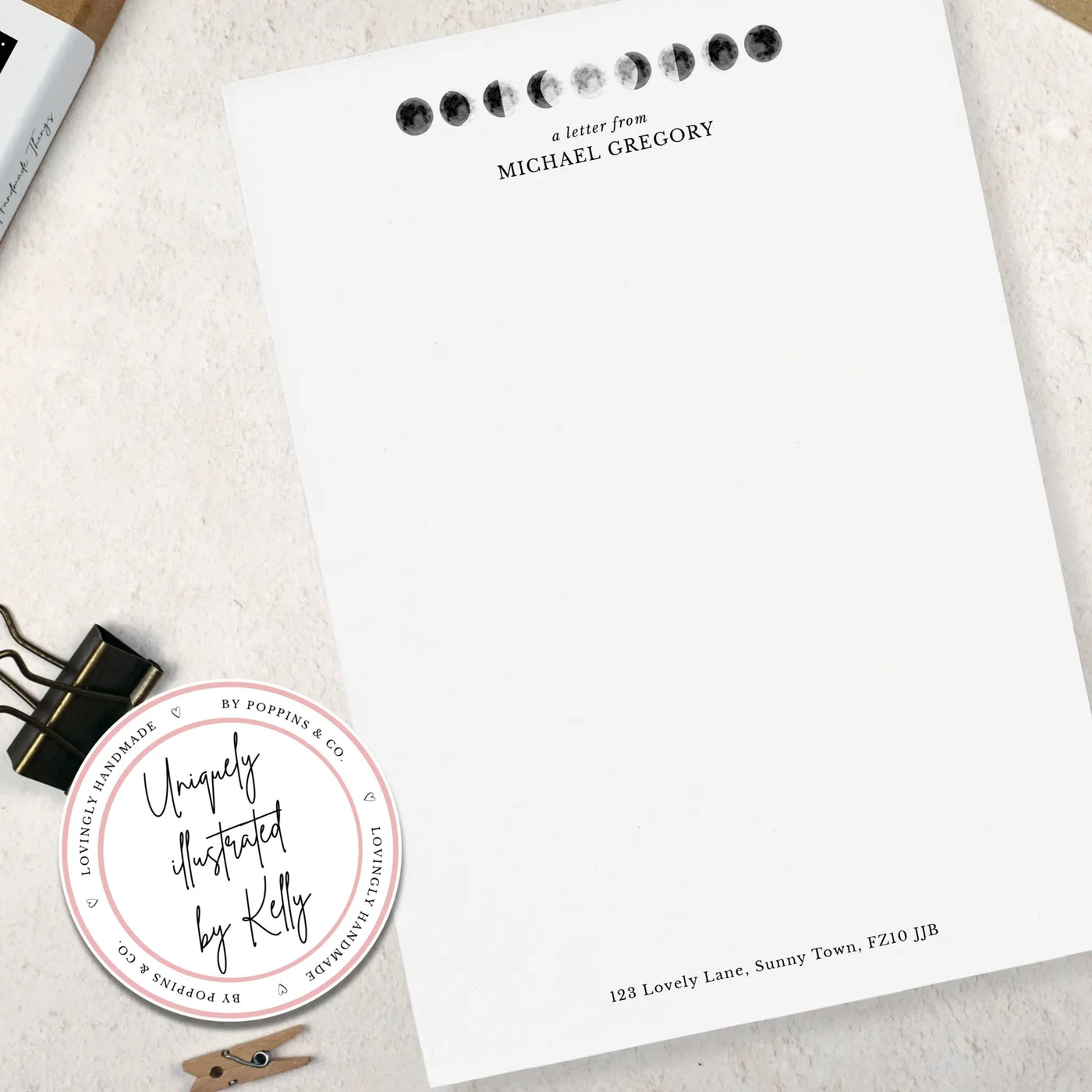 Single sheet of personalised moon themed writing paper on pale background 
