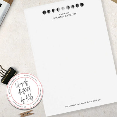 Single sheet of personalised moon themed writing paper on pale background 