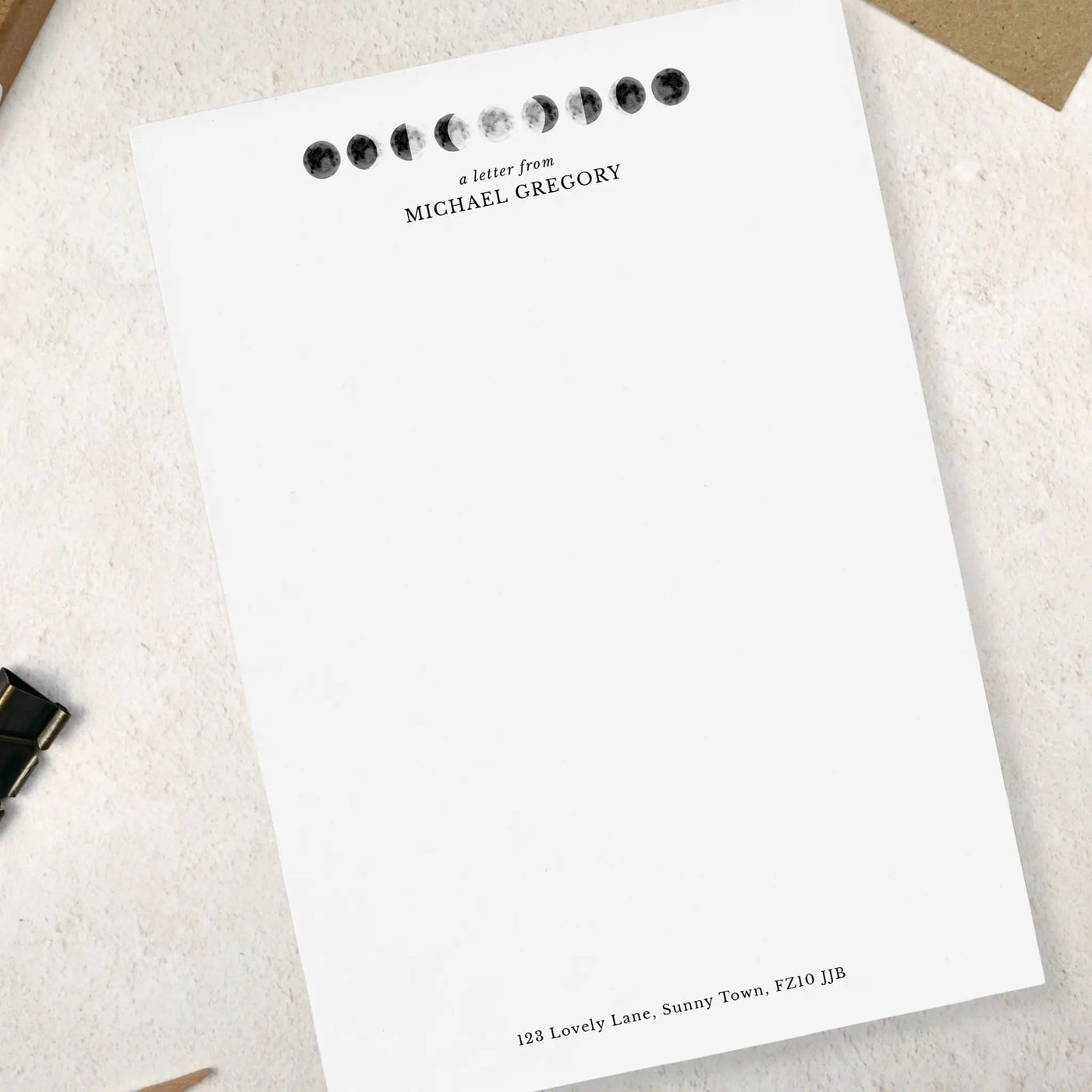 Single sheet of personalised moon themed writing paper on pale background 