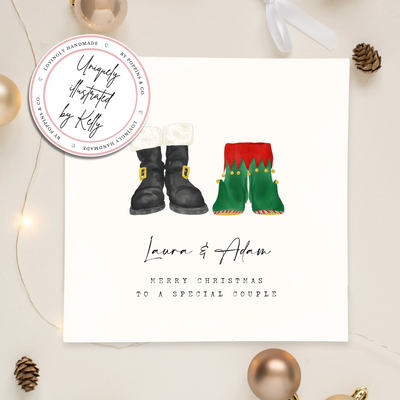 A square christmas card featuring unique watercolour illustrations of a pair of Santa boots and elf boots side beside. Beneath the boots personalised text reads 'Laura and Adam - merry christmas to a special couple.