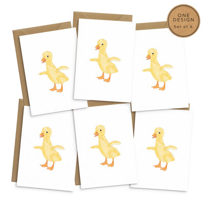 A set of 6 white greetings cards featuring an adorable illustration or a yellow duckling. No text. 6 cards are laid out on top of brown recycled envelopes. sticker on corner reads 'one design- set of 6'. Easter greetings cards by Poppins and co.