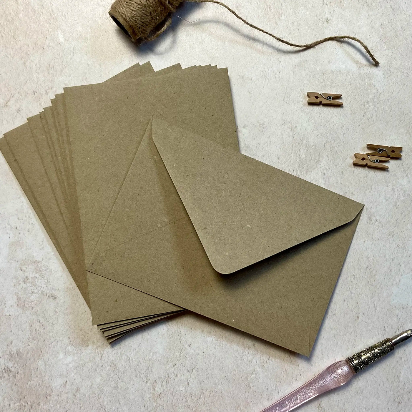 A stack of recycled C6 sized brown kraft envelopes from Poppins and co