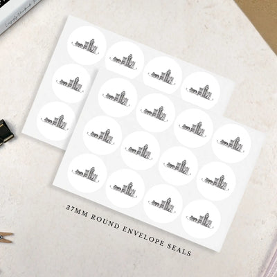 Sheet of 37mm round envelope seals with a design of a row of tiny black and white houses on a textured surface.
