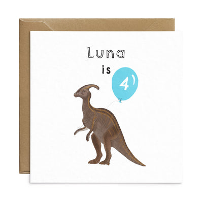 Dinosaur birthday card with unique illustration of a Parasaurolophus holding a blue balloon. Personalised text reads 'Luna is' with the number '4' on the balloon. Square card with brown Kraft envelope. Kids Birthday Card by Poppins and co.
