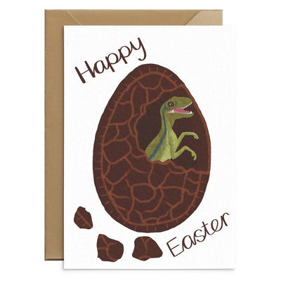 An unusual easter card for kids featuring a green velociraptor hatching from inside chocolate easter egg. Brown text reads 'happy easter'. Illustration on white A6 card with recycled envelopes. Easter cards by Poppins and co.