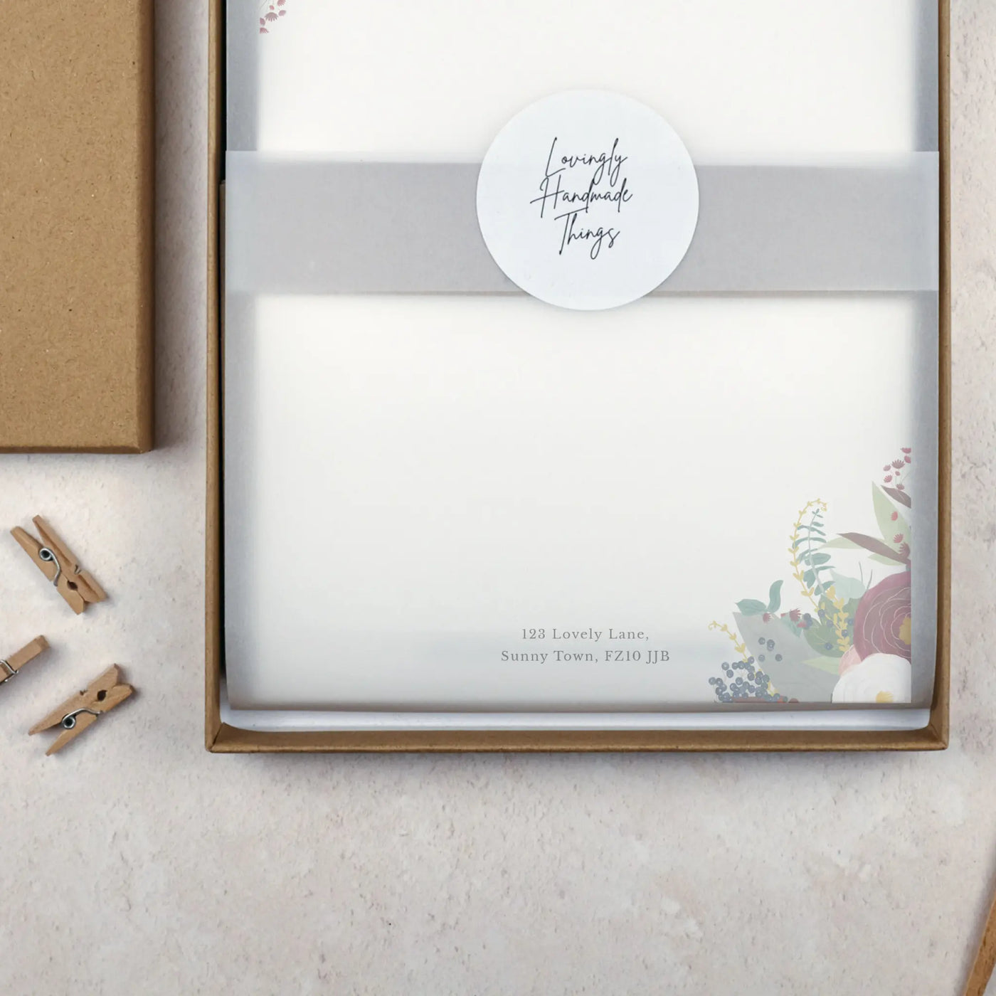 Packaged writing paper set in a brown kraft stationery gift box. The paper is wrapped with vellum and sealed with a white sticker which reads 'Lovingly Handmade Things'.