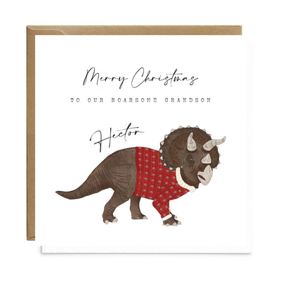 A personalised square greetings card featuring a unique illustration of triceratops in a christmas jumper and personalisable text reading 'Merry Christmas to our roar some grandson Hector'.